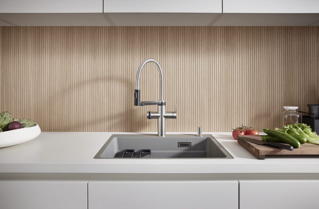 Graue Silgranit-Spüle ETAGON mit BLANCO CHOICE Armatur vor einer Holzrückwand