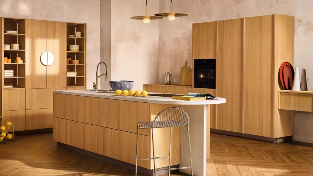Küche mit glatten Echtholzfronten neoFLAT in Eiche Bianco, Kochinsel mit abgerundeter heller Arbeitsplatte und offenen Regalen