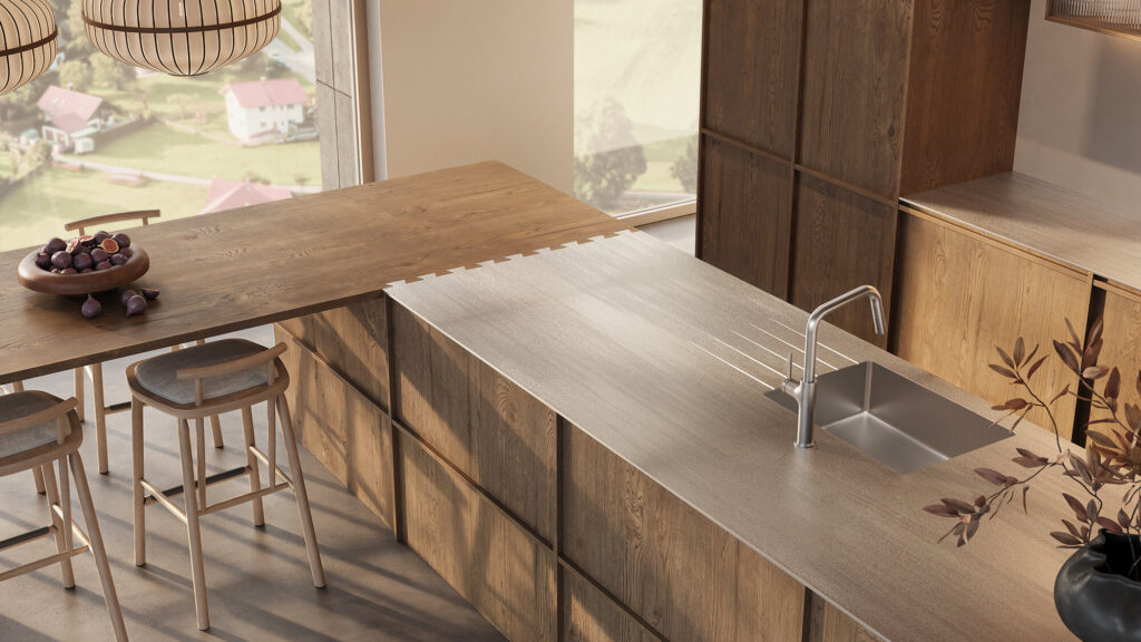 Küche mit Edelstahl-Arbeitsplatte und Becken zwischen Holzfronten, daneben eine Essbar aus Holz mit Hockern